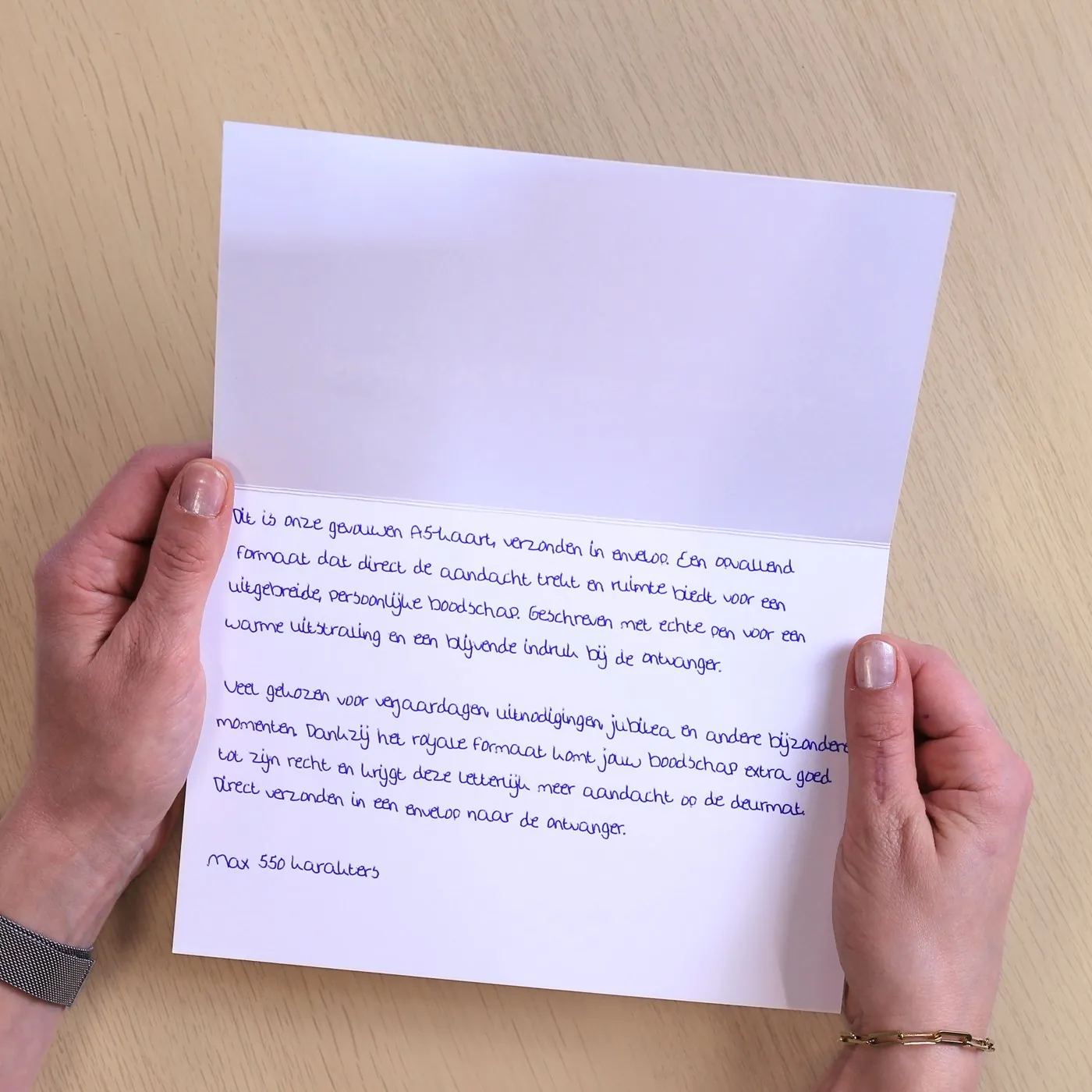 Horizontaal gevouwen A5-kaart, opengeslagen, onderaan met een echte pen geschreven