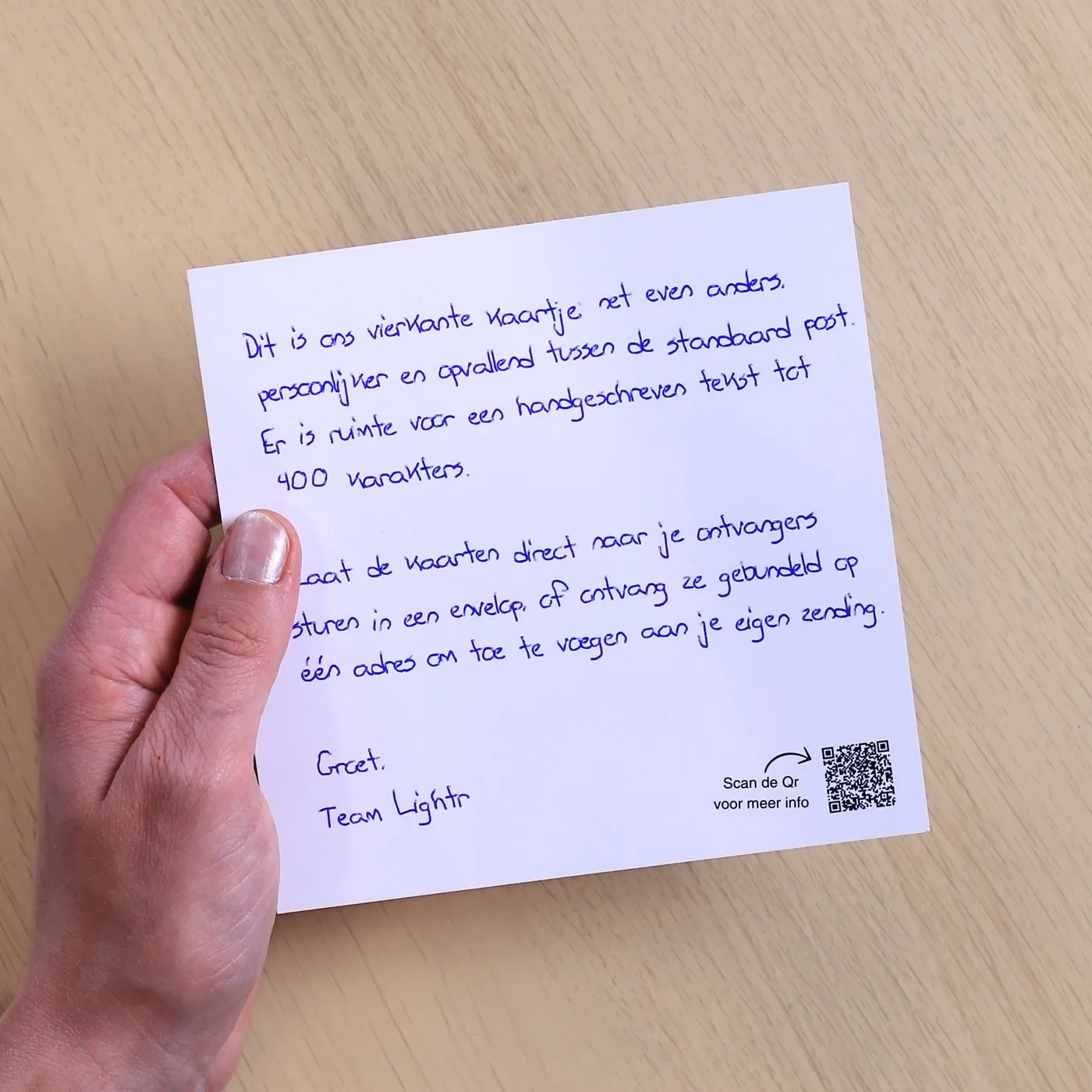 Vierkant plano kaartje met een handgeschreven tekst en een QR-code